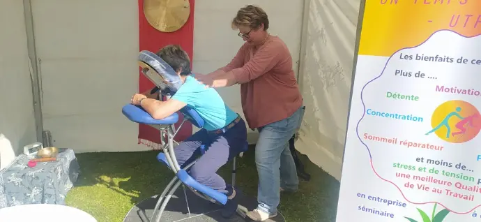 Photo prise lors de l'événement "Live à Gisacum", organisé par le département de l'Eure et le Tangram. Une praticienne en massage assis offre un moment de détente à un participant, confortablelent installé sur une chaise ergonomique. Ce massage en entreprise favorise la relaxation et le bien-être au travail, tout en réduisant le stress. Une meilleure QVT